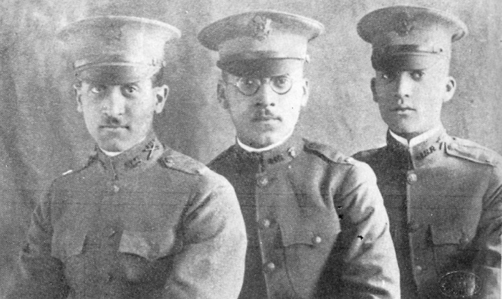 Three young black men seated together in military uniform, shown from the chest up